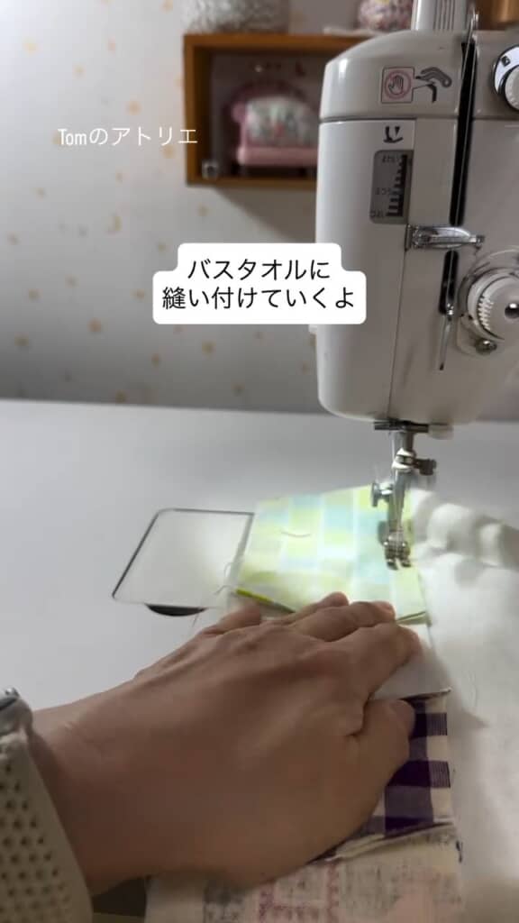 端切れをバスタオルに縫い付けるTOMさん