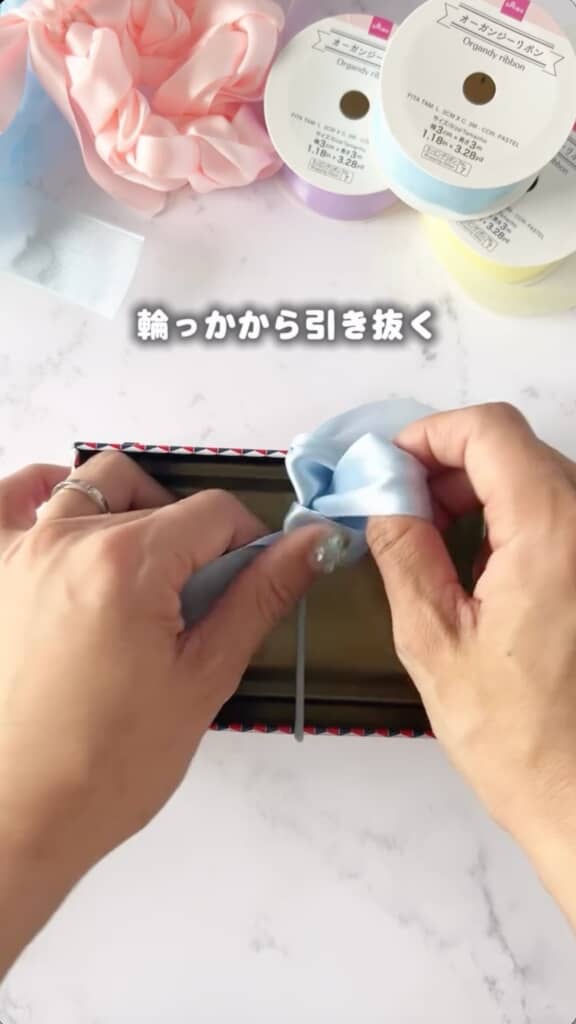 ゴムを中心にしてくるくる指で編んでいきます
