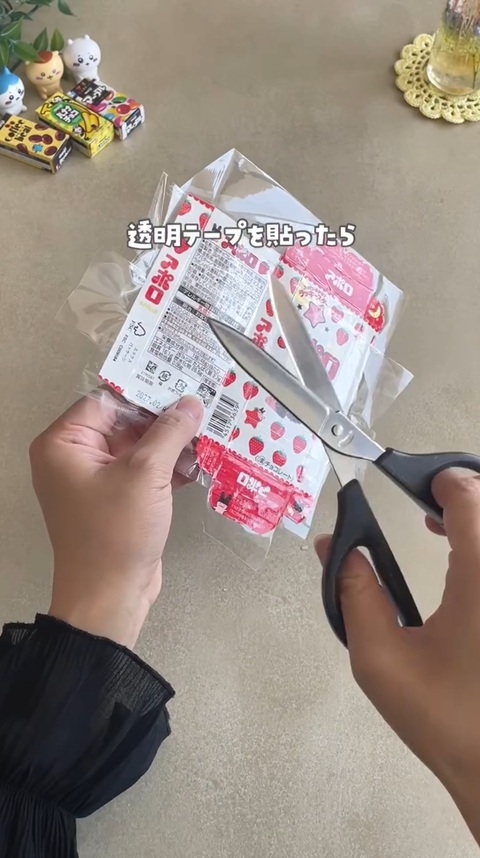 開いた箱の表面に透明テープを貼り、箱から はみ出た部分をはさみでカットする