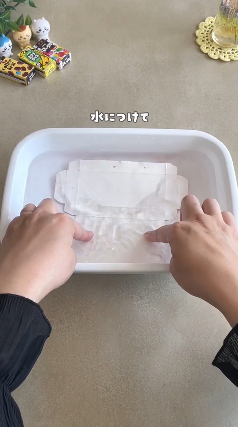 バットにはった水に、テープをはった箱を沈めて水に浸す