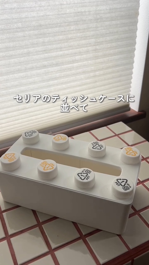 白いティッシュケースの上にペットボトルのふたを並べています。この時点で既に、レゴブロックっぽくはあります