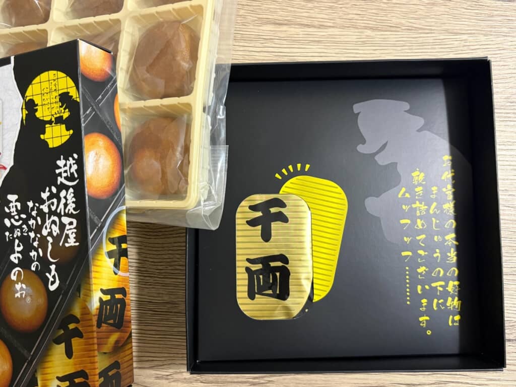 (2/3)箱を開けるとおまんじゅうが並んでいますが、実はまだ仕掛けが。フタのメッセージに導かれて下の段を開けると、思わぬ展開が待っています