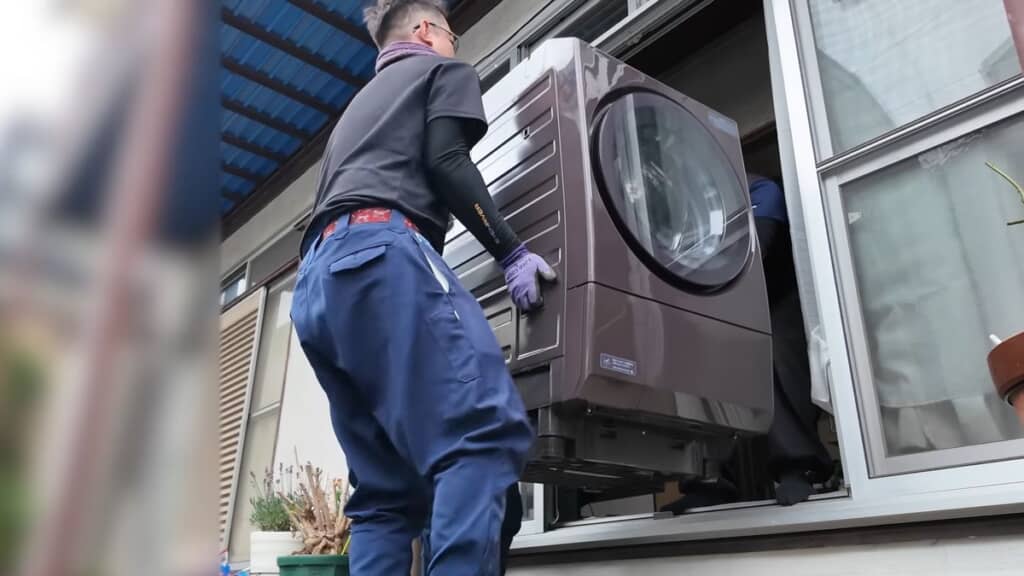 小屋内部に置いてあった洗濯機を室内へ移す様子