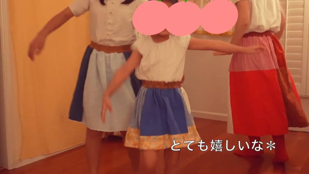 完成したスカートを着用して踊る3人