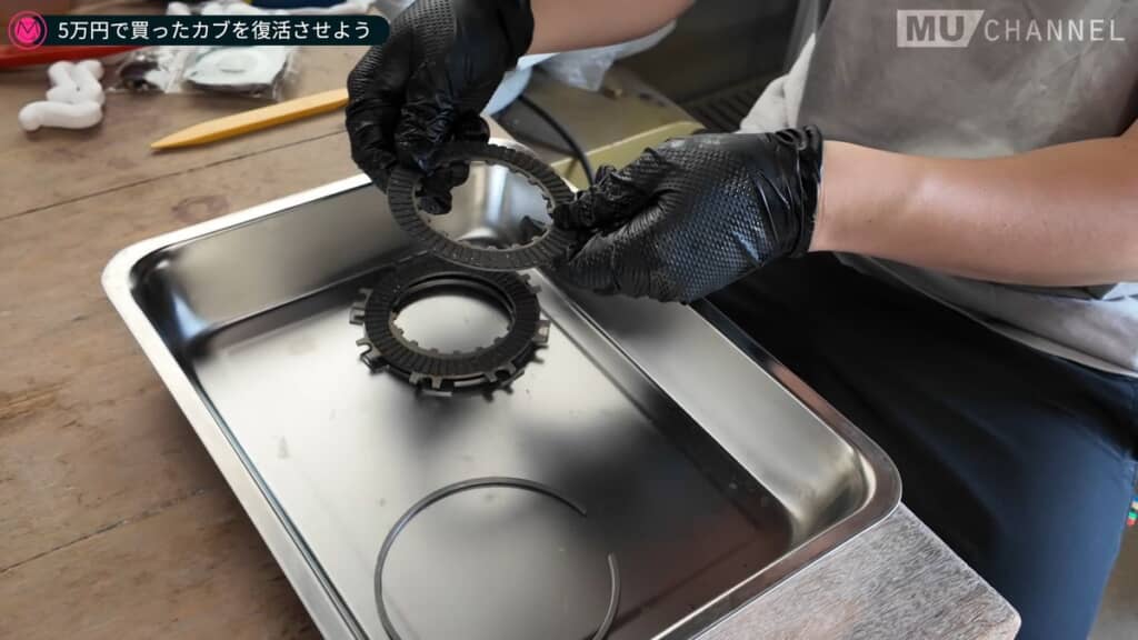 分解した部品を手に妻へ再び説明する夫
