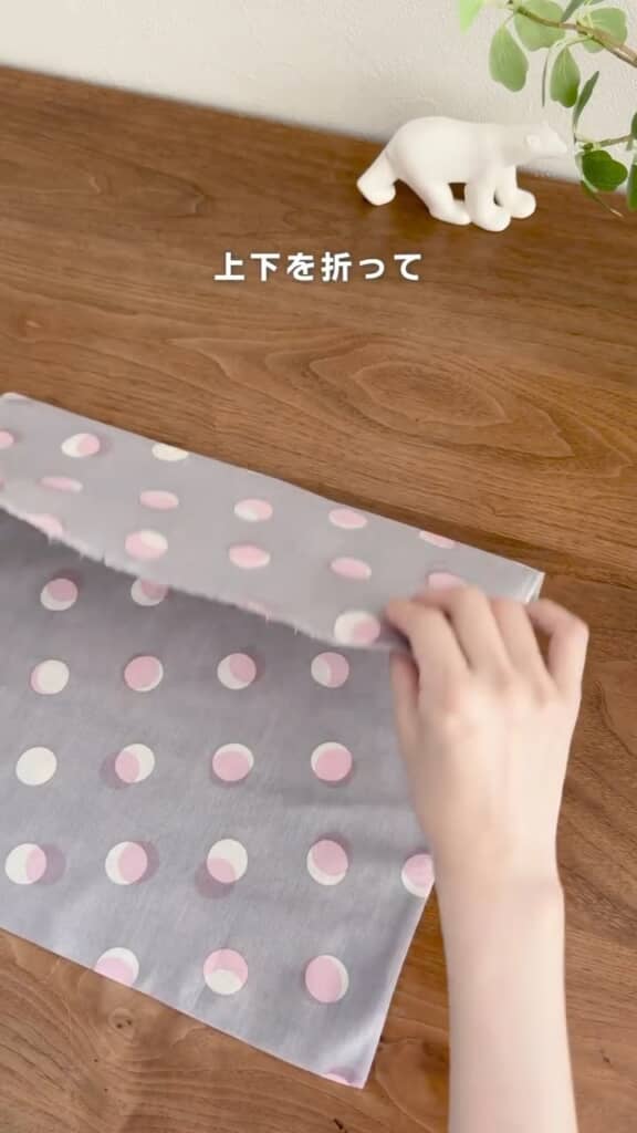 手ぬぐいの両端をそれぞれ内側へ折り畳む