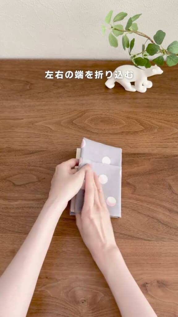 本のカバーへ沿うように、手ぬぐいを両側から折り込む