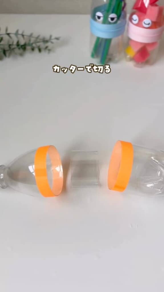 （2/7）まっすぐ切れるようマスキングテープで目印を付け、500ミリリットルのペットボトルをカッターで3つのパーツに切り分けます