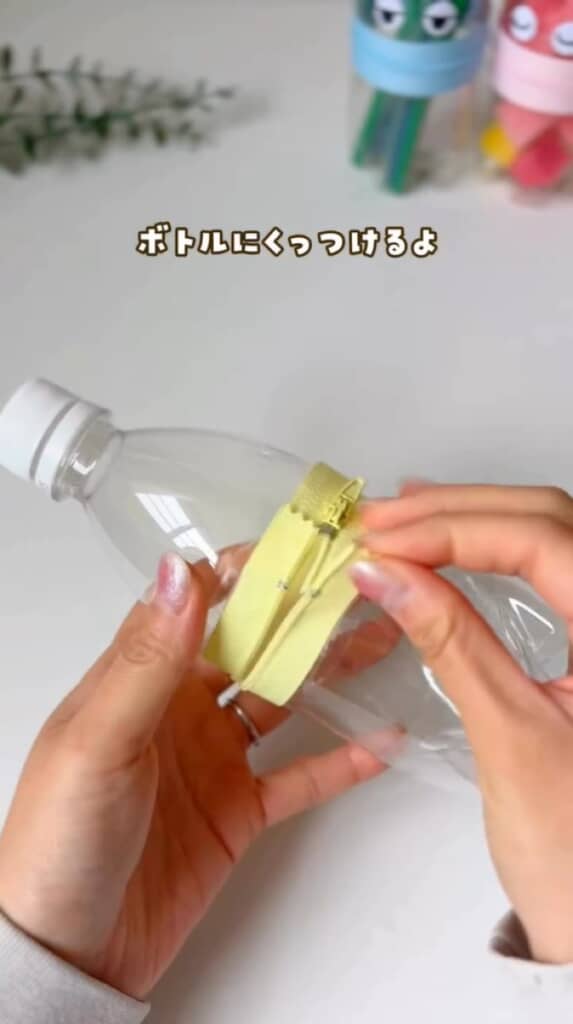 （5/7）両面テープを付けたファスナーを、カットしたペットボトルの上下パーツに貼り付け。開け閉めできる楽しい仕掛けができてきました