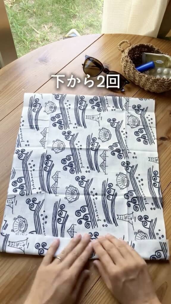 手ぬぐいを半分に折り、下から2回折ります