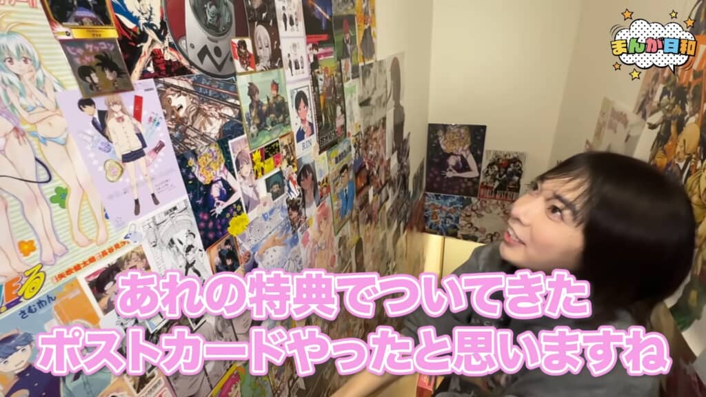 アニメポスターが密集した壁を見上げるハヤン君
