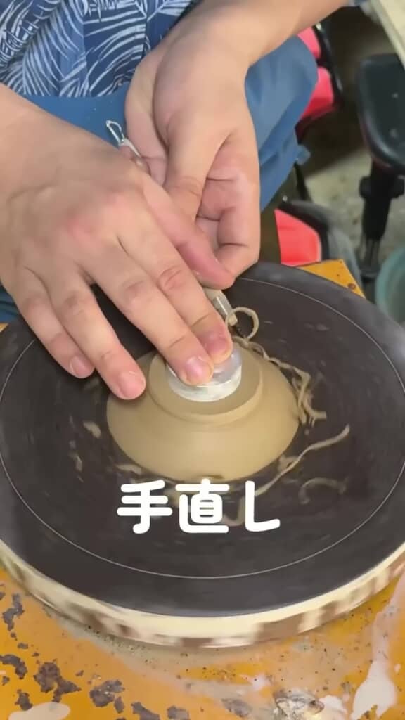 ろくろの上で皿の形を整える