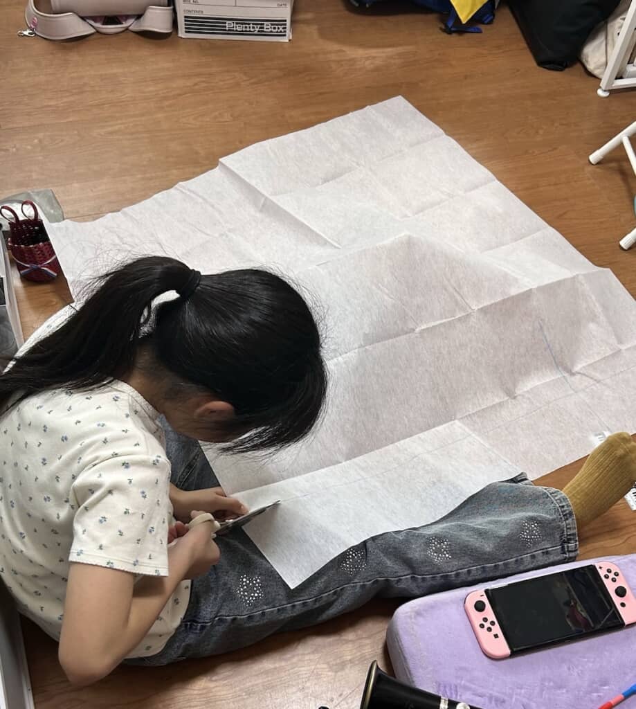 大きな型紙を広げ、ハサミでカット