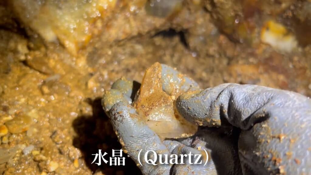 砂と泥にまみれている水晶