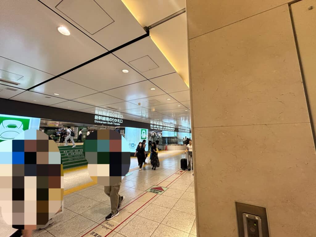 新幹線南のりかえ口付近の駅構内通路、モザイク加工された人物と行き交う利用者たち
