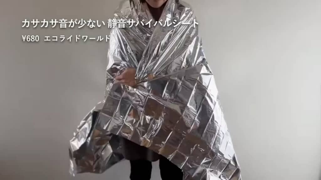 「カサカサ音が少ない静音サバイバルシート」に包まって見せている