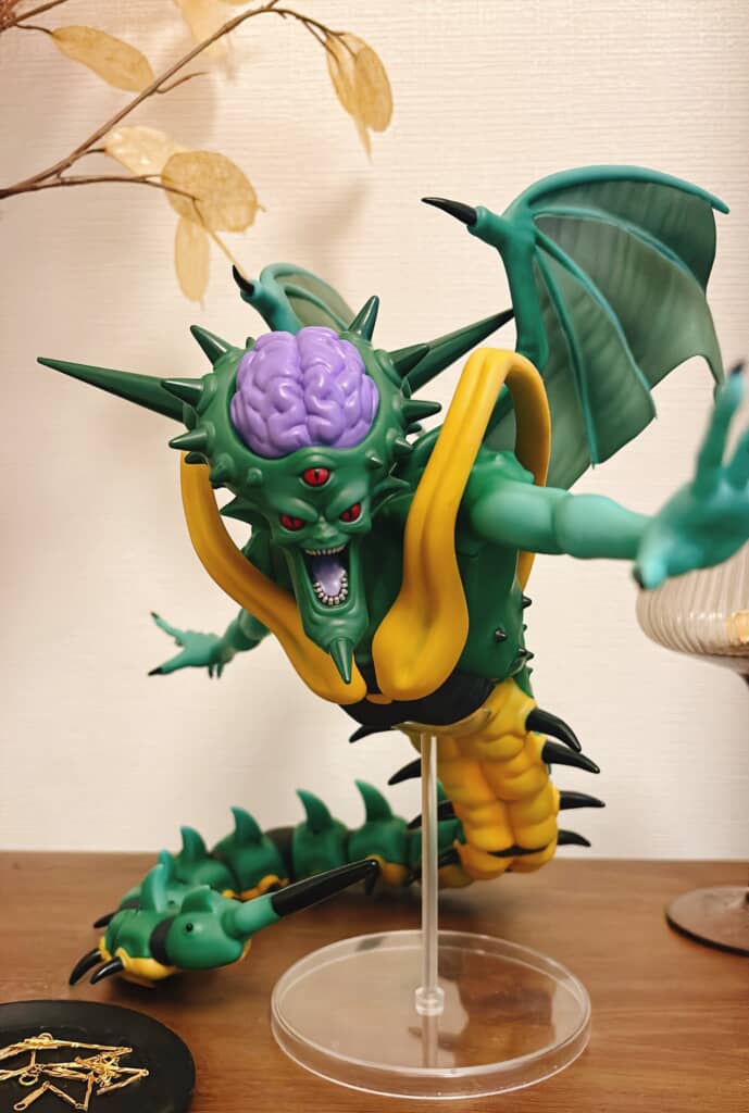 脳が露出した頭部と赤い目を持つ緑色オルゴのフィギュアの正面アップ