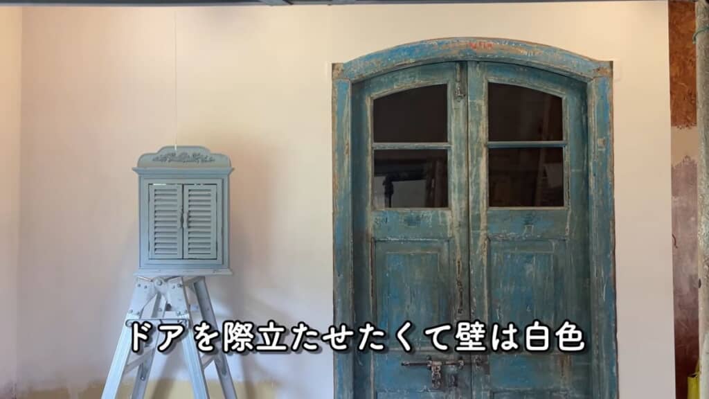 寝室とリビングを分ける白い壁と青いドア