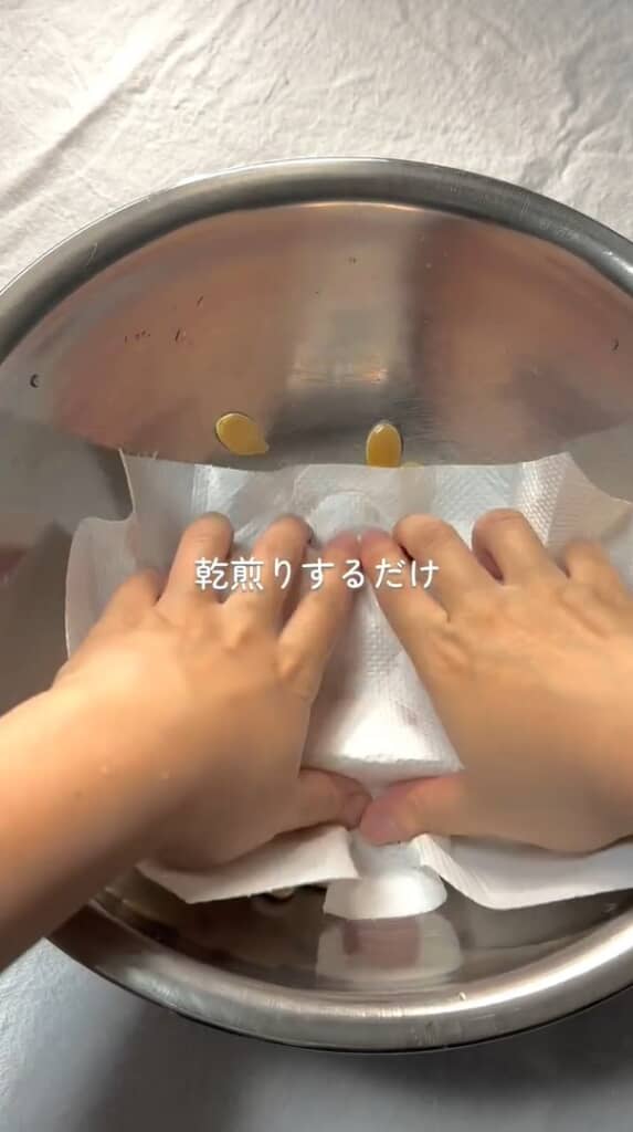 キッチンペーパーで押さえて種の水気を取っています
