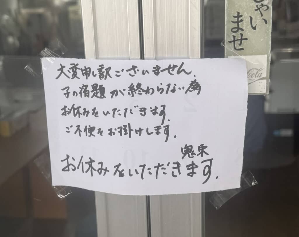 店舗ドアに貼られた「本日休業」の手書き張り紙、鬼束署名入り