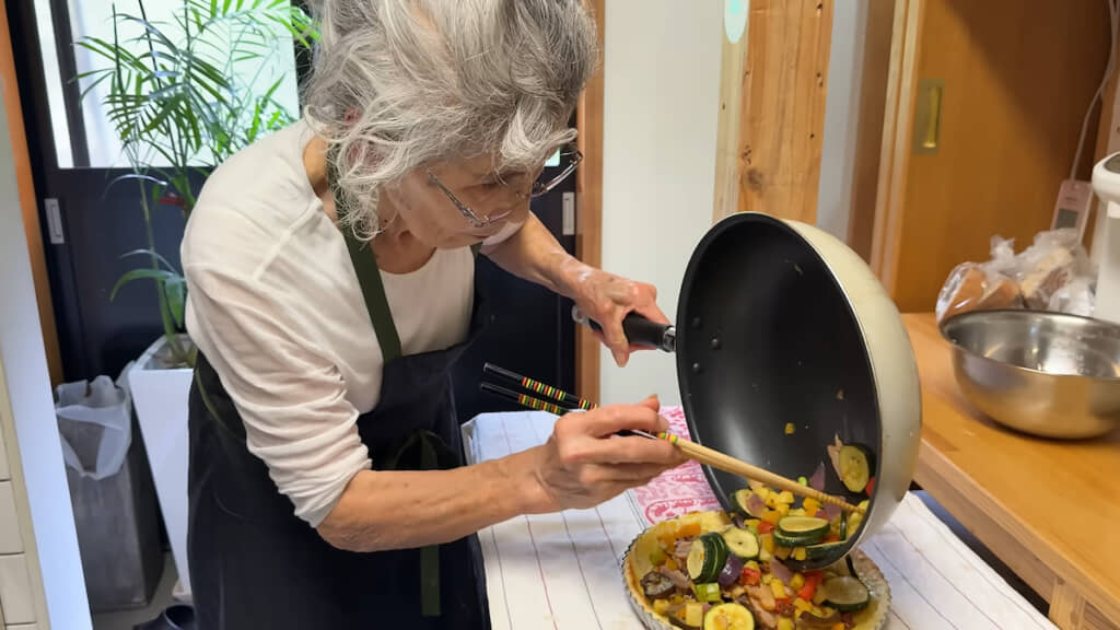 キッシュの土台にソテーした野菜をのせる三女・弘子さん