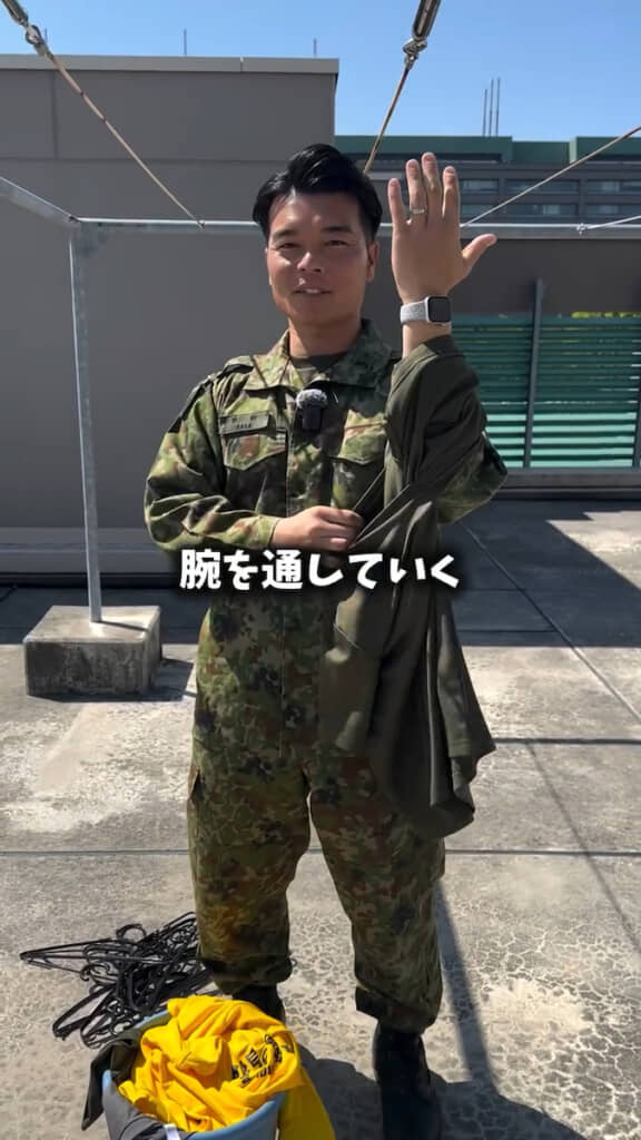 袖口からえりぐり（首を通す穴）へ腕を通す