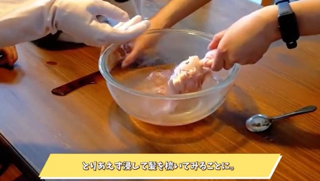 髪をお湯に浸しています