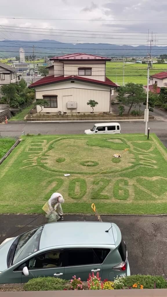 芝刈り機に貯まった芝をゴミ袋へ