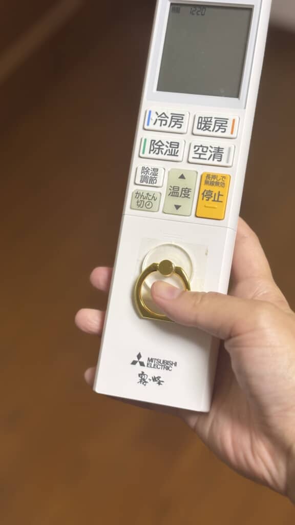 母がリモコンにスマホリングを貼り付ける
