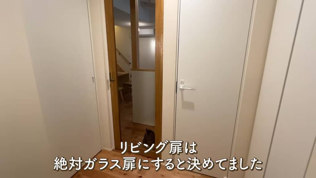 ガラス扉のリビング側にいる猫