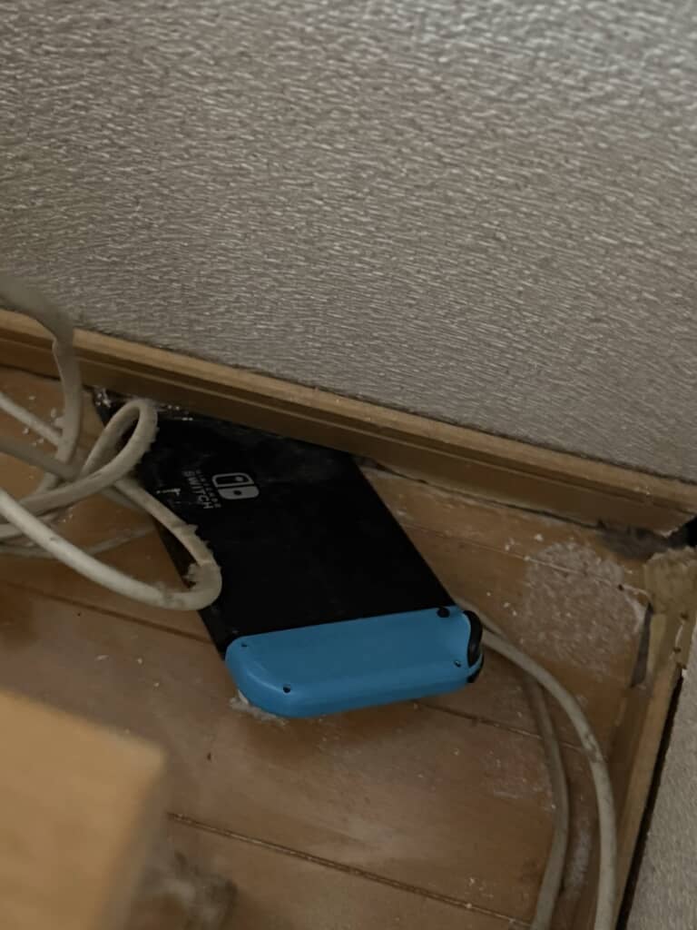 地震により、壁と床の隙間に挟まってしまったNintendo Switch