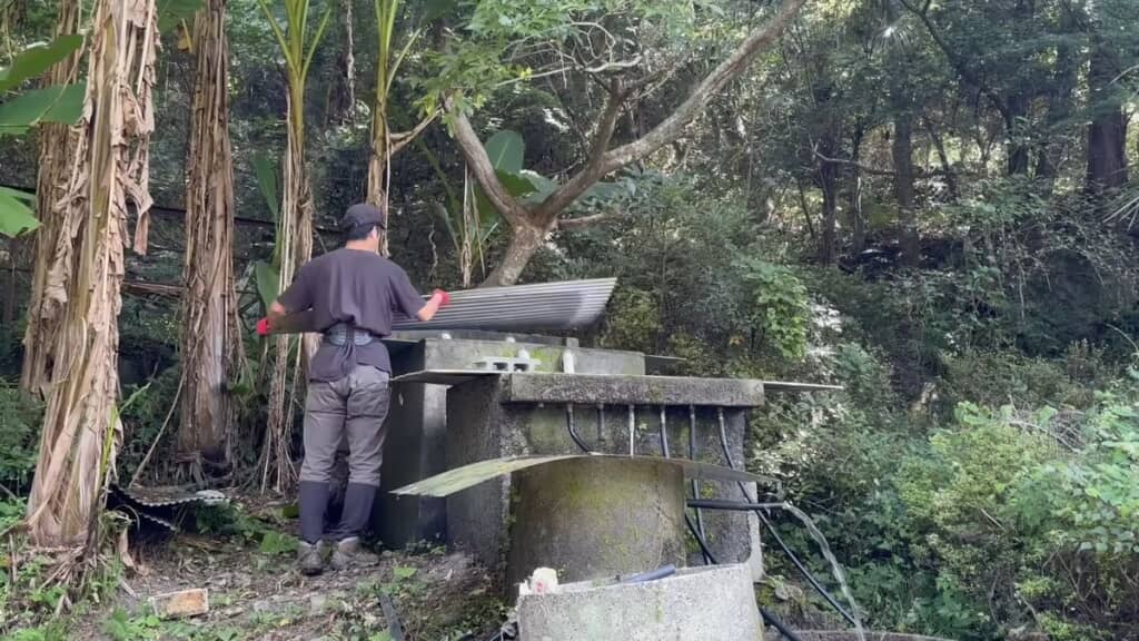 山奥にあるろ過水槽を手入れする様子