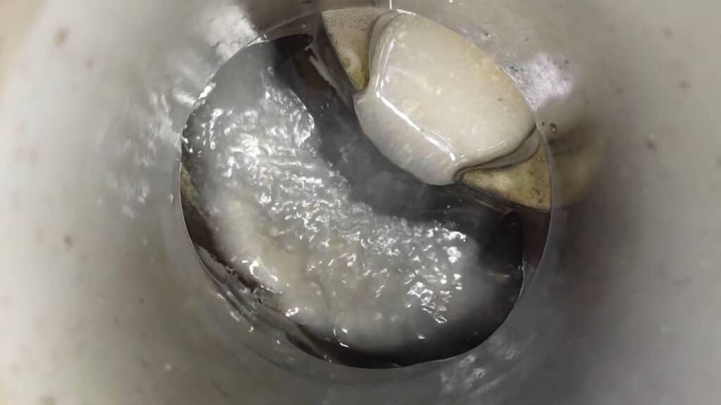 高圧洗浄で配管の油汚れを落とす様子