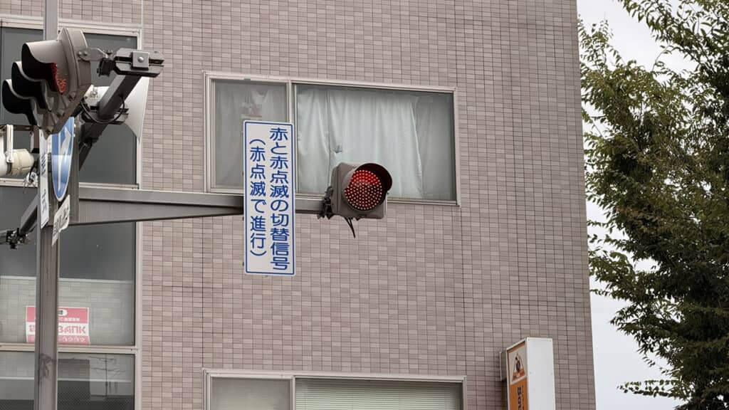赤点滅と赤点灯が切り替わるタイプで隣には意味が記されている一灯式信号機