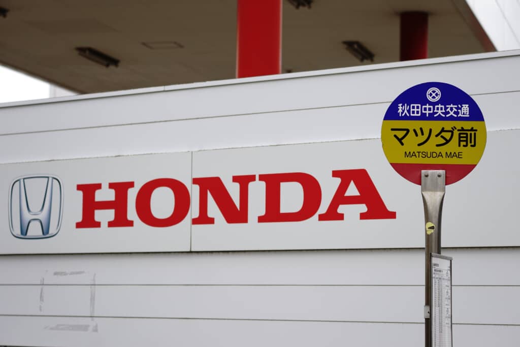 秋田中央交通「マツダ前」バス停と、背後にあるHONDAの大きな看板