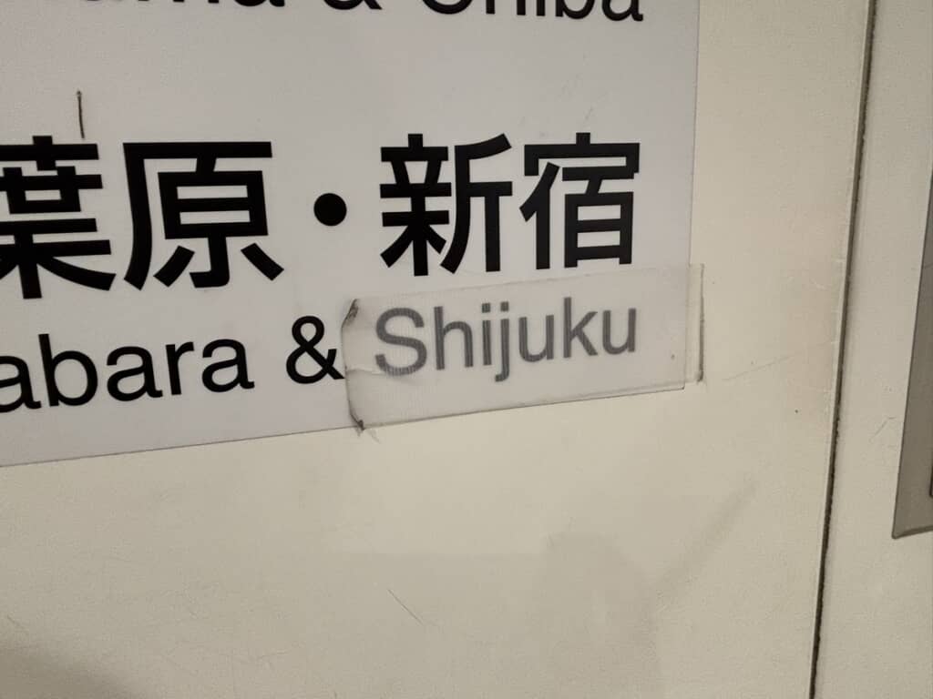 白い養生テープ越しに見える「Shijuku」