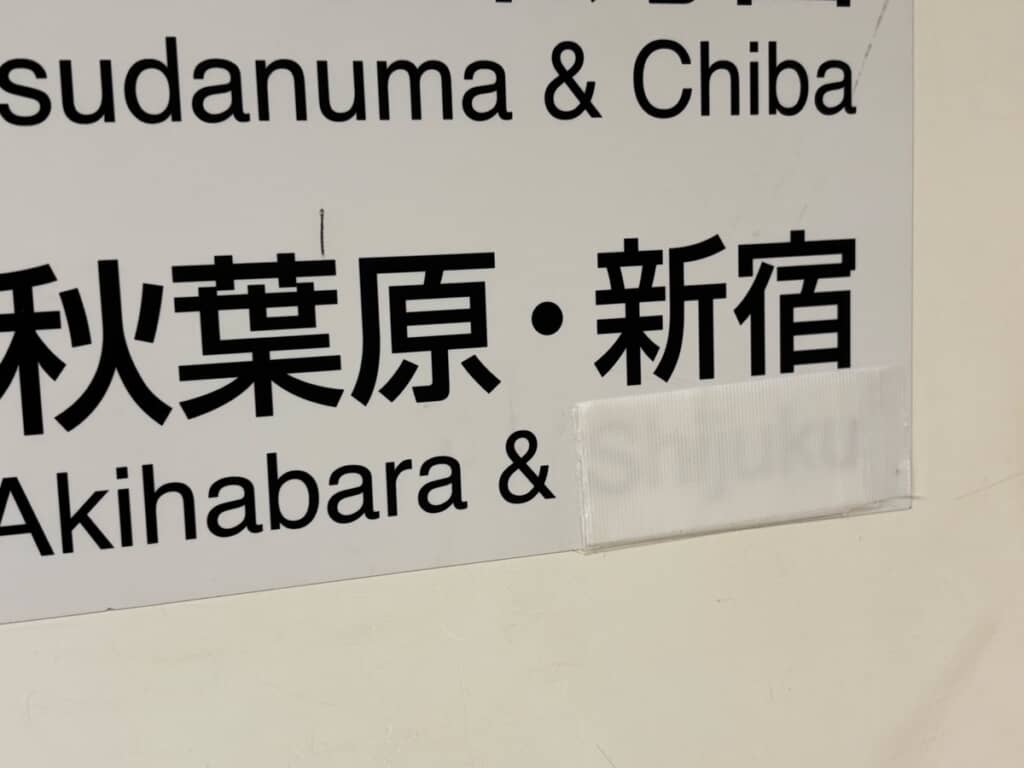 テープを重ね貼りして見えにくくなった「Shijuku」