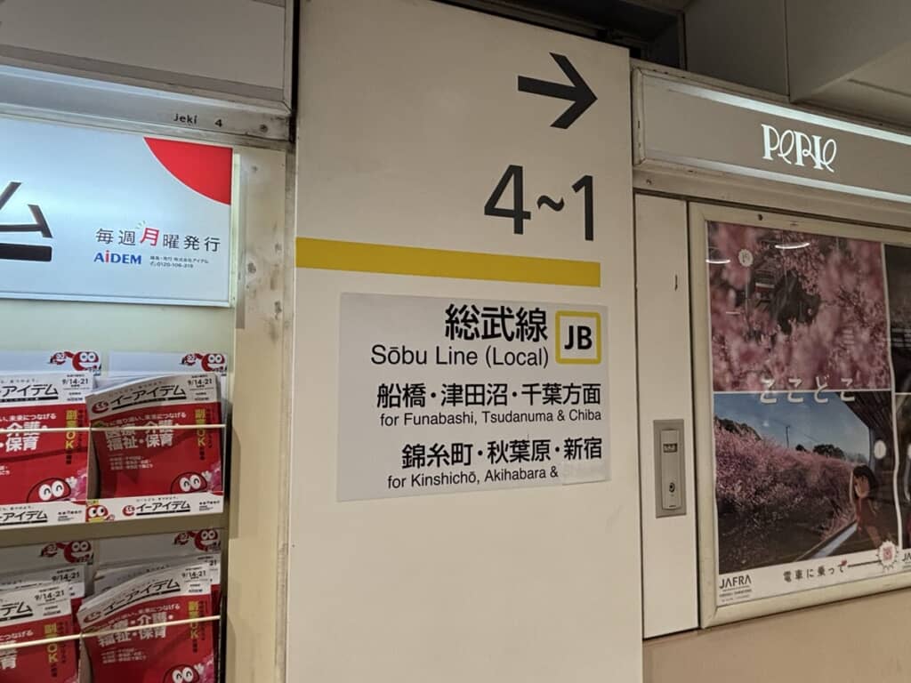 テープを重ね貼りして誤記が見えにくくなった案内表示