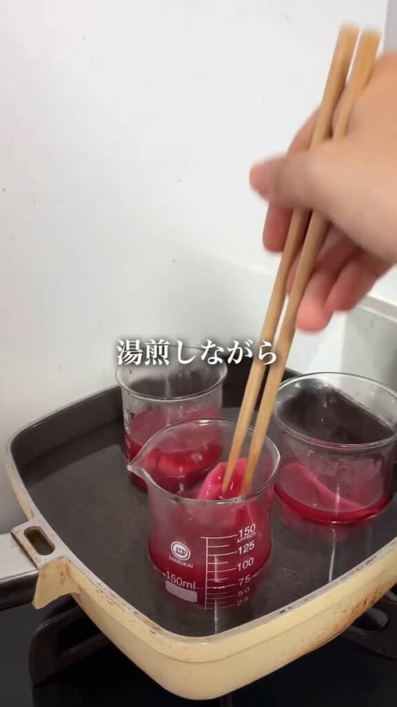 染色液に浸した布と糸を、容器ごと湯煎