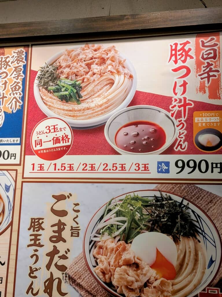 丸亀製麺の期間限定メニュー「旨辛豚つけ汁うどん」。どのサイズでも同一価格です
