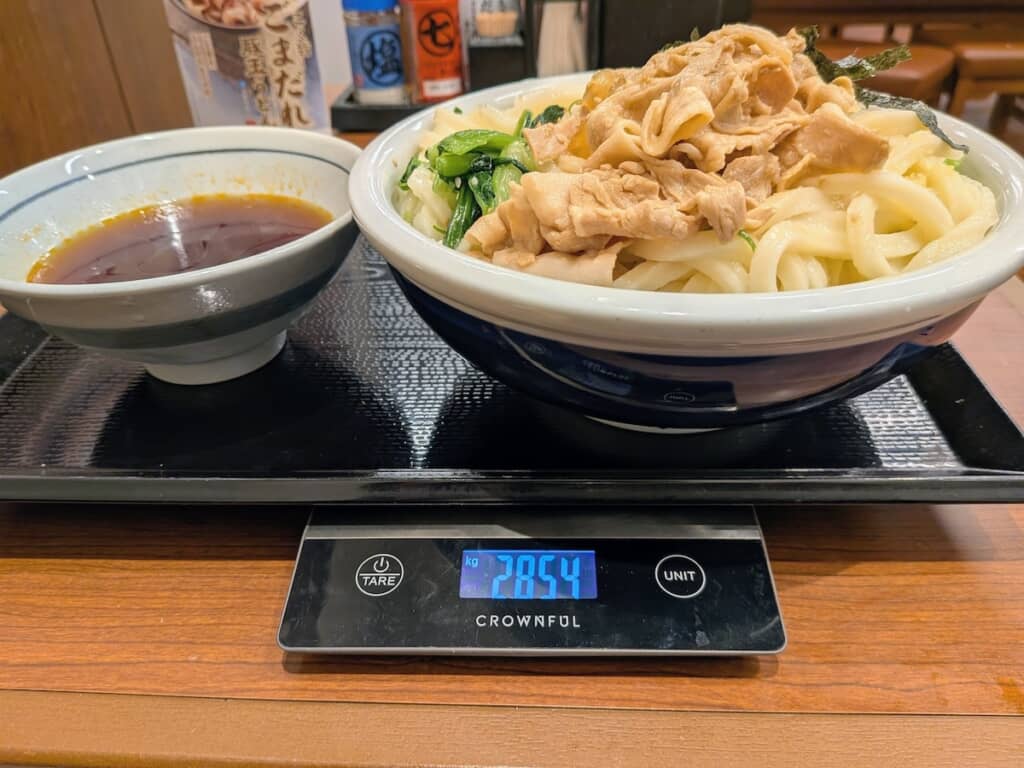 3玉で注文した旨辛豚つけ汁うどん。容器込みとはいえ、3キロ近い重さがあるとはすごい……！