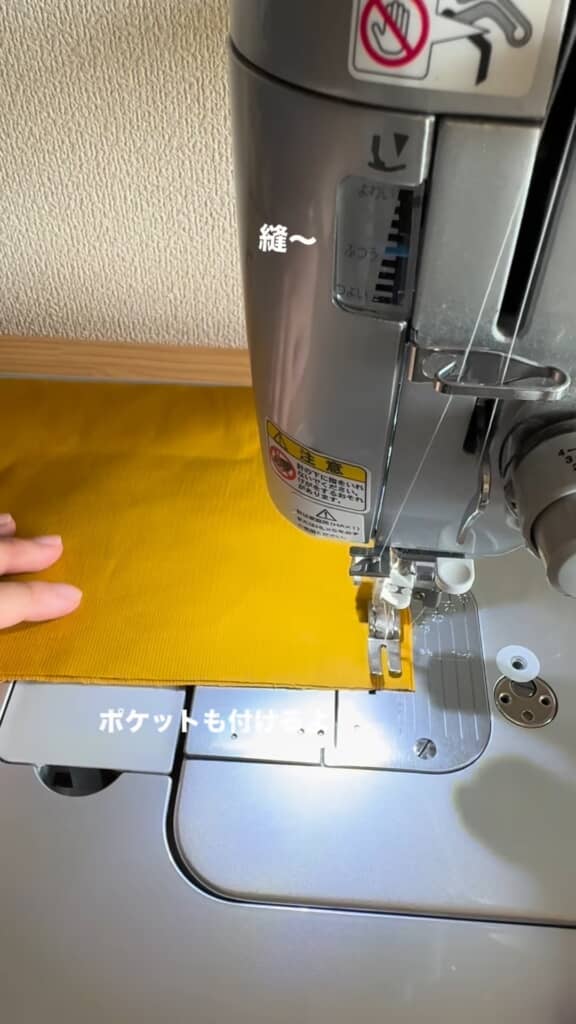 山吹色の布をミシンで縫うところ
