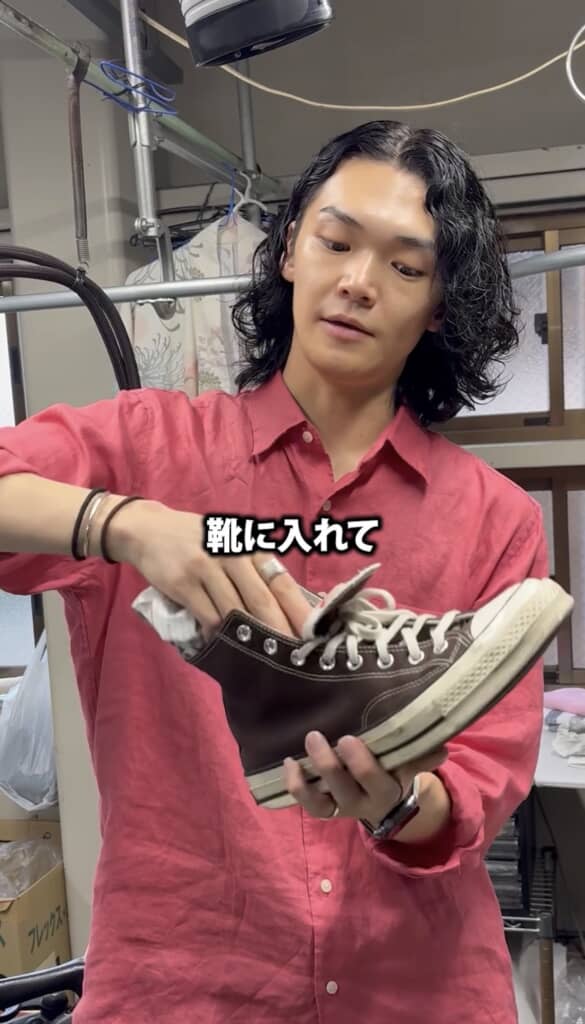 （5/7）ふんわり筒状にした新聞紙を、そのまま濡れた靴の中へ。靴の形に沿うように軽く整えれば準備完了です