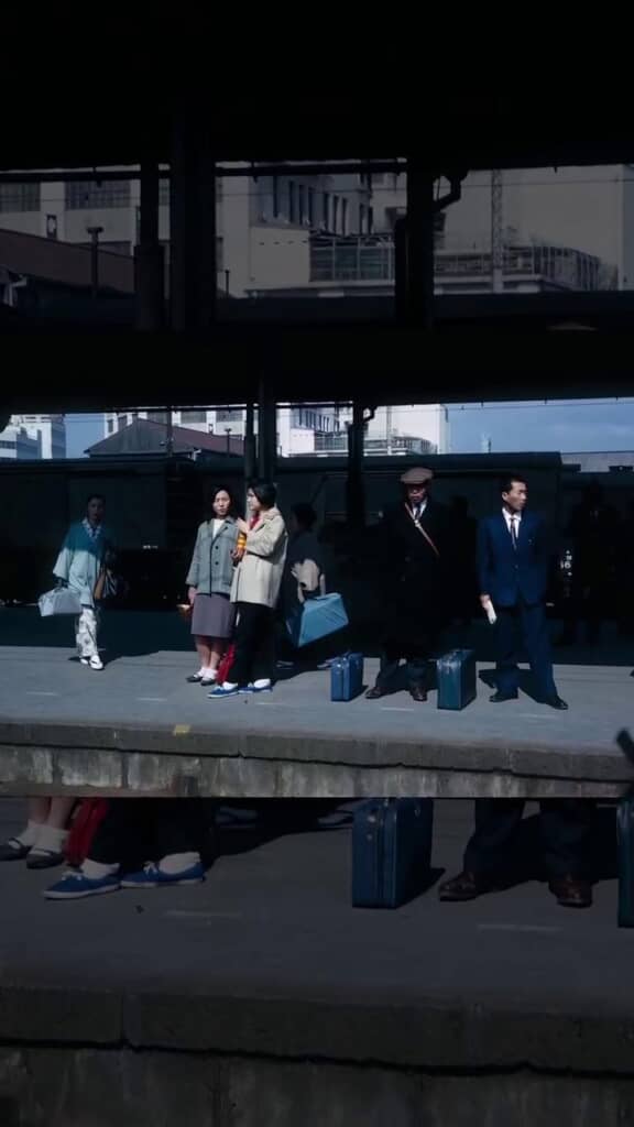 駅のホームで列車を待つ人々