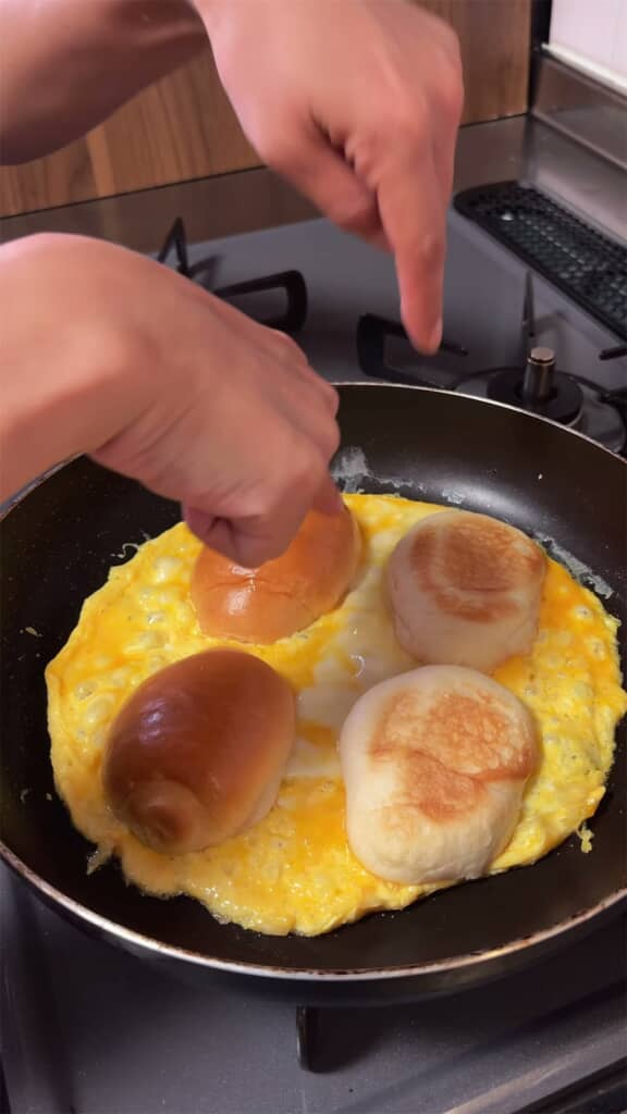 チーズと卵を焼き、半分に切ったロールパンをのせます