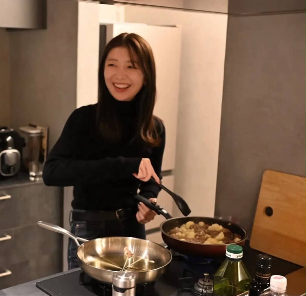 キッチンで料理するYuriさん