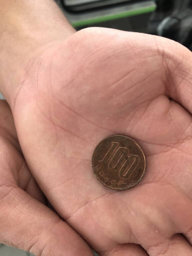 サビて茶色くなった100円玉をアップで撮った写真