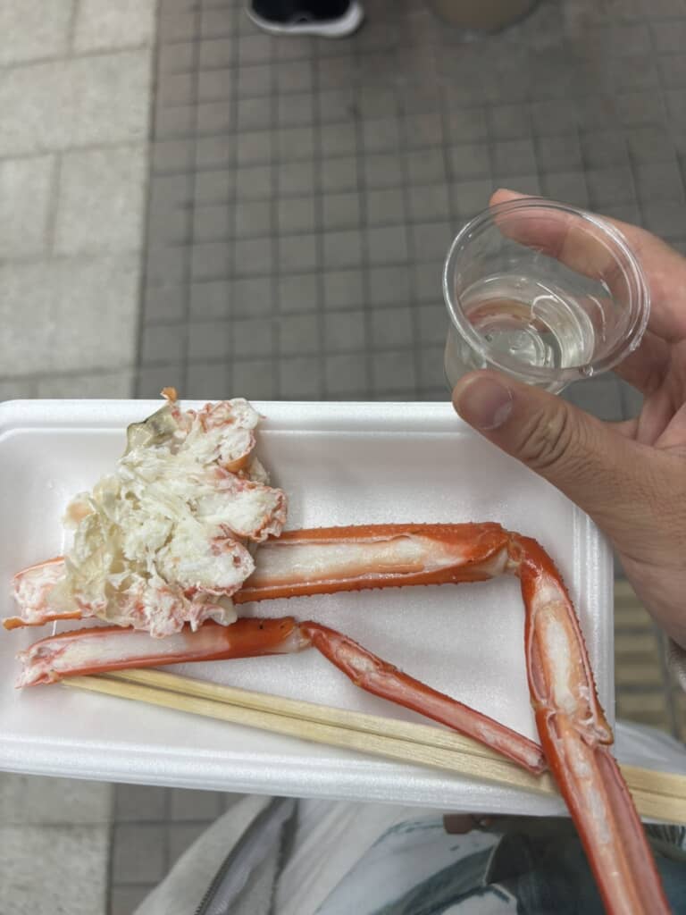 魚津駅観光案内所前で投稿者がもらった無料の酒とカニ