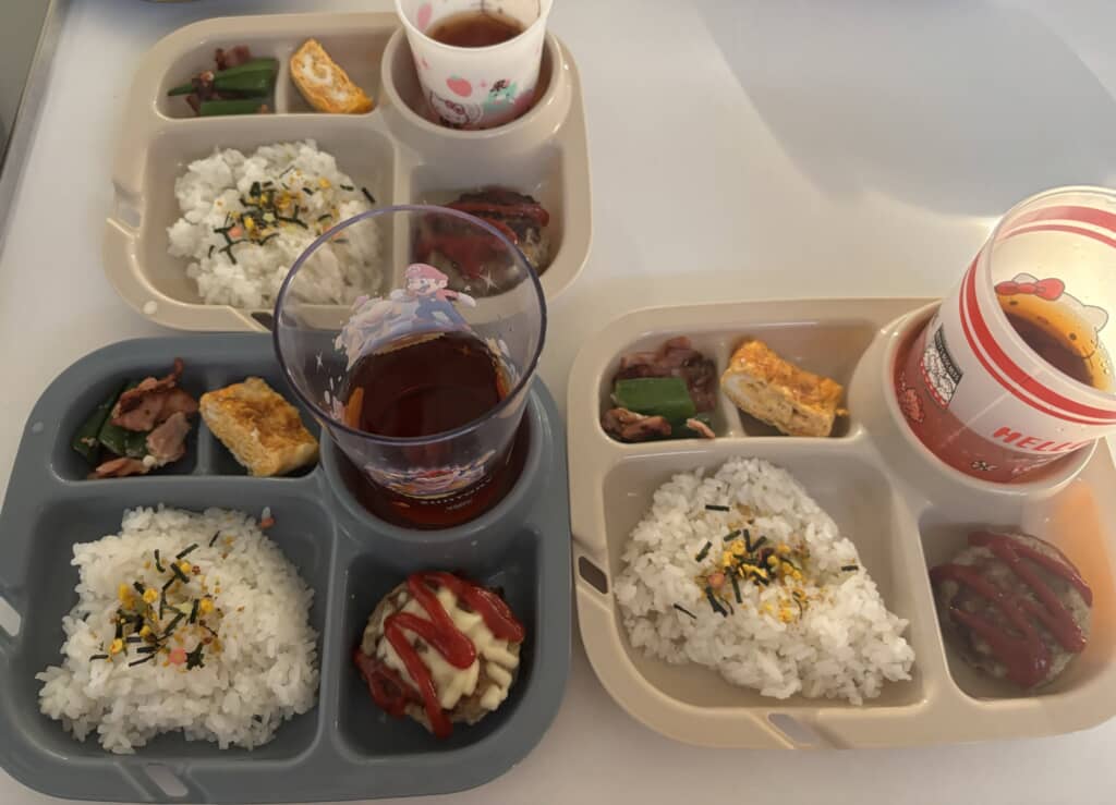ふりかけごはんとハンバーグ、卵焼き、オクラとベーコンのおかずを盛り付けた3人分のワンプレートごはん
