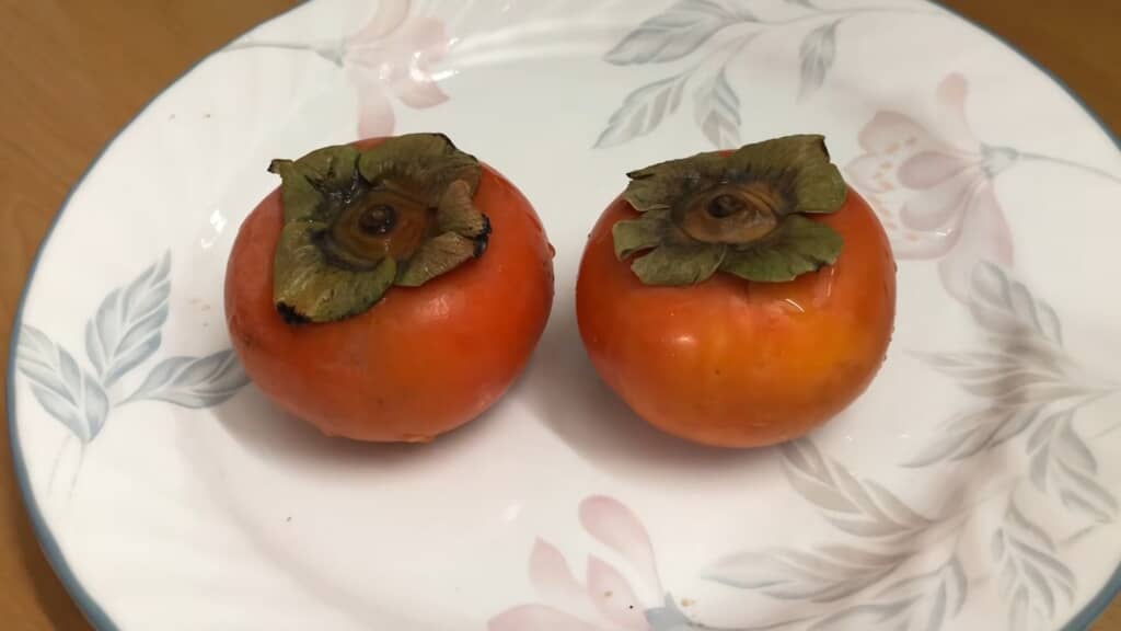 皿に並べた2個の柿
